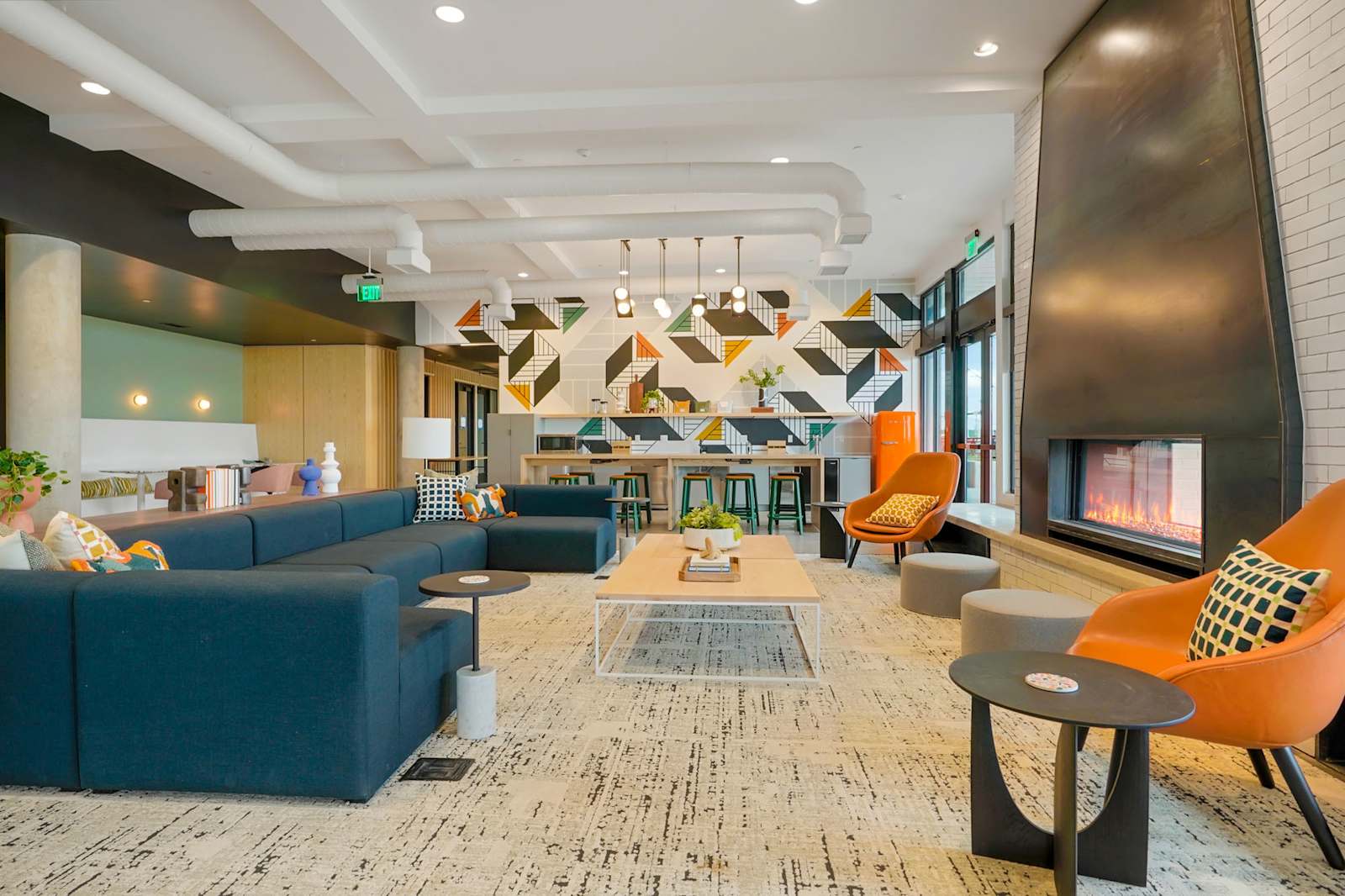 Completed lobby with geometric wall patterns, blue seating and a fireplace