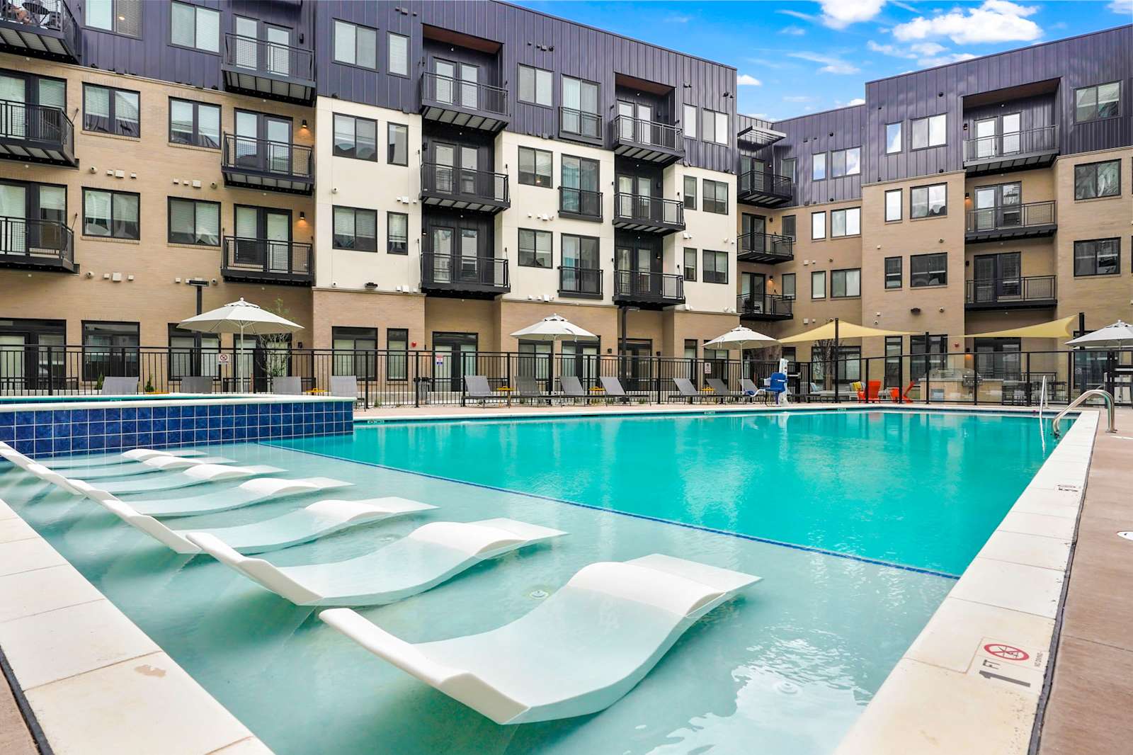 Pool courtyard framed by balconies and residential façades